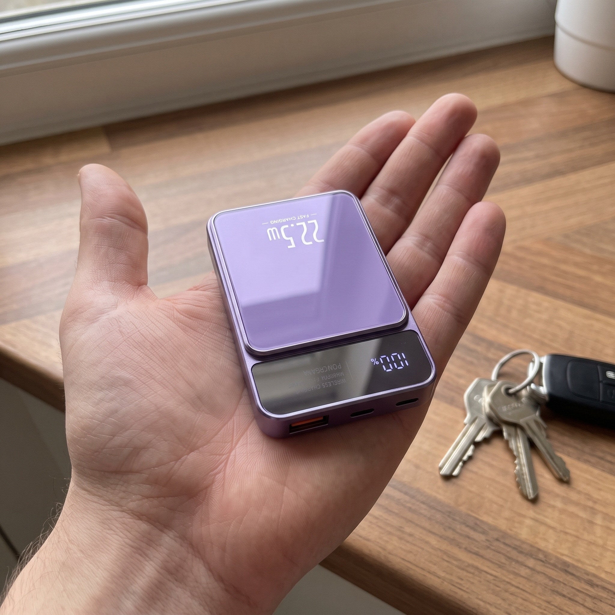 Purple CarryCharge shown at natural palm size
